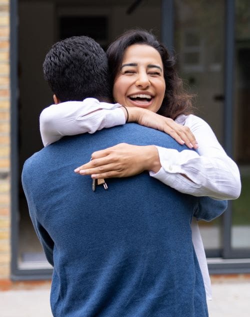 A couple hugging each other with the women holiday a set of keys