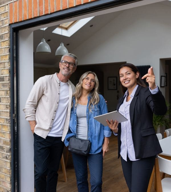 A couple being shown around a house by an estate agent