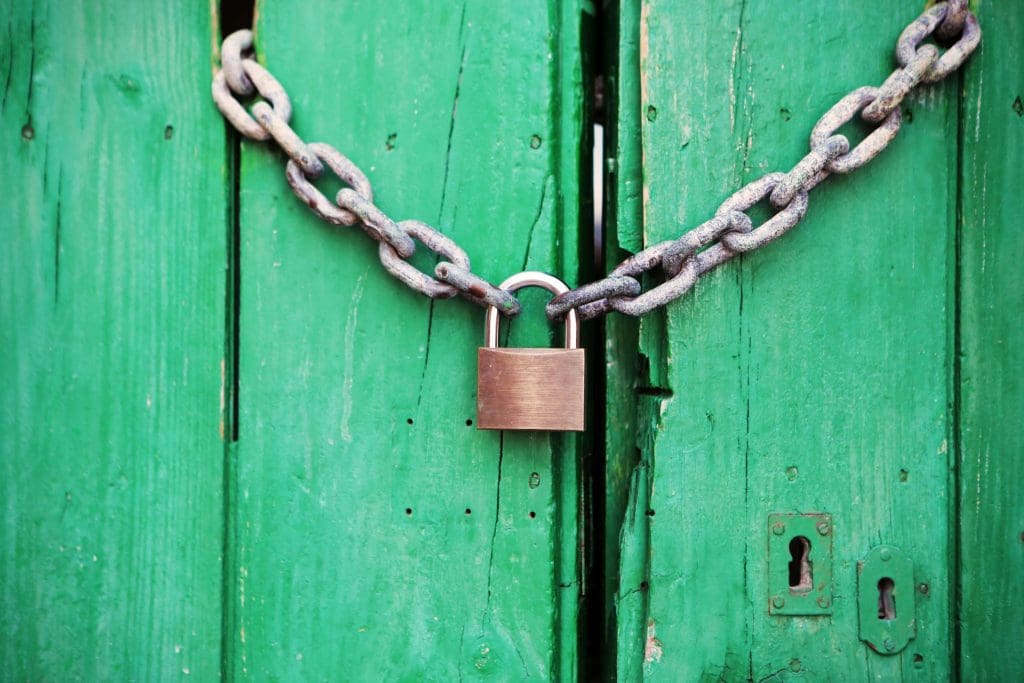 Secured Loans | Lock and chain around a green fence